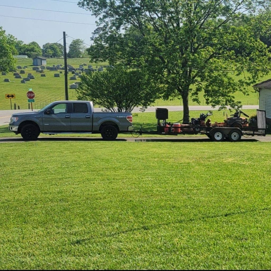P&S Lawn Care truck and trailer loaded with mowing equipment